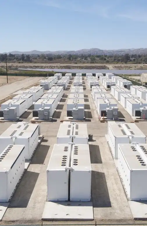 Parc industriel de stockage d’énergie composé de conteneurs de batteries disposés en rangées sur une plateforme dédiée