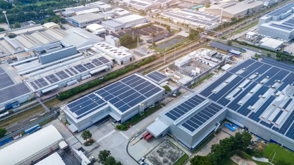 Vue aérienne d’un site industriel équipé de toitures photovoltaïques produisant de l’électricité solaire pour l’autoconsommation